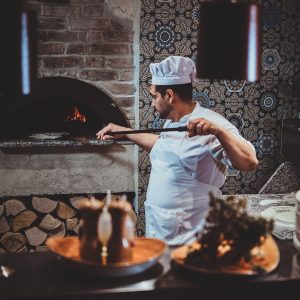 experienced-chef-is-putting-his-pizza-oven-using-special-giant-spatula-1-300x300