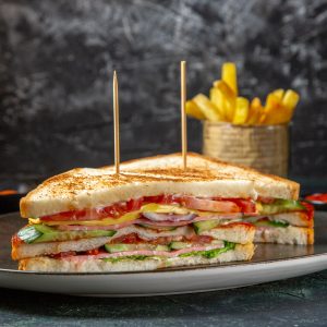 front-view-delicious-ham-sandwiches-inside-plate-with-french-fries-dark-surface