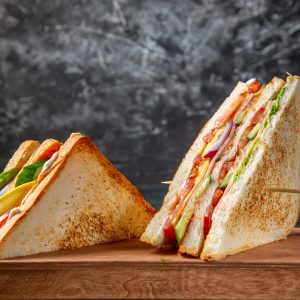 front-view-delicious-ham-sandwiches-wooden-board-dark-surface